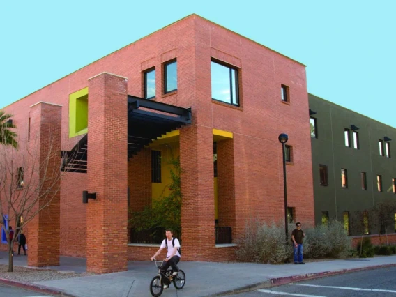 Image of Pueblo de la Cienega residence hall, a red brick building with pops of color.