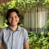 Illana Valenzuela in a gray shirt facing the camera with ENR2 vines and building in the background.